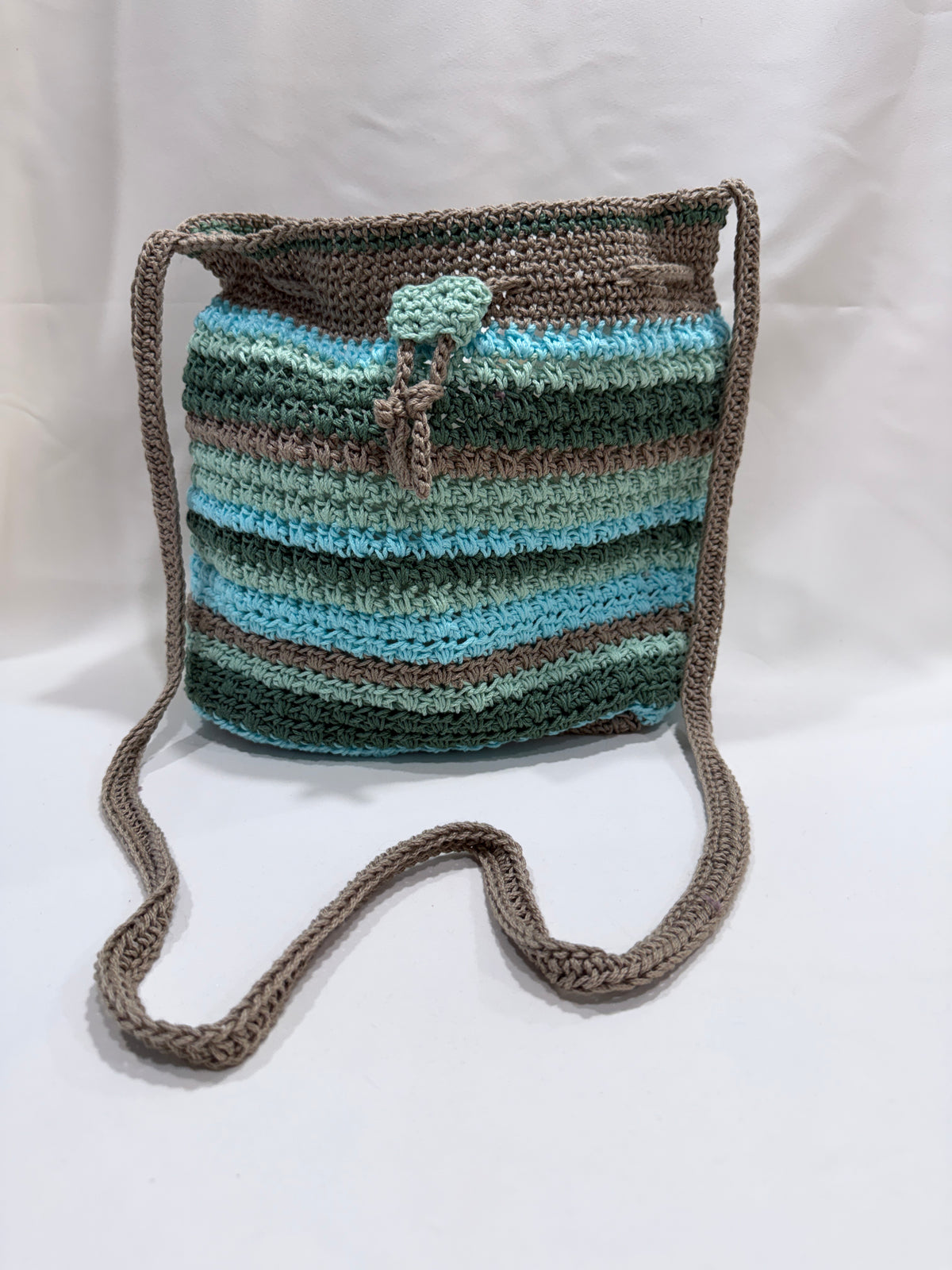 Crocheted bag with striped pattern on a white background