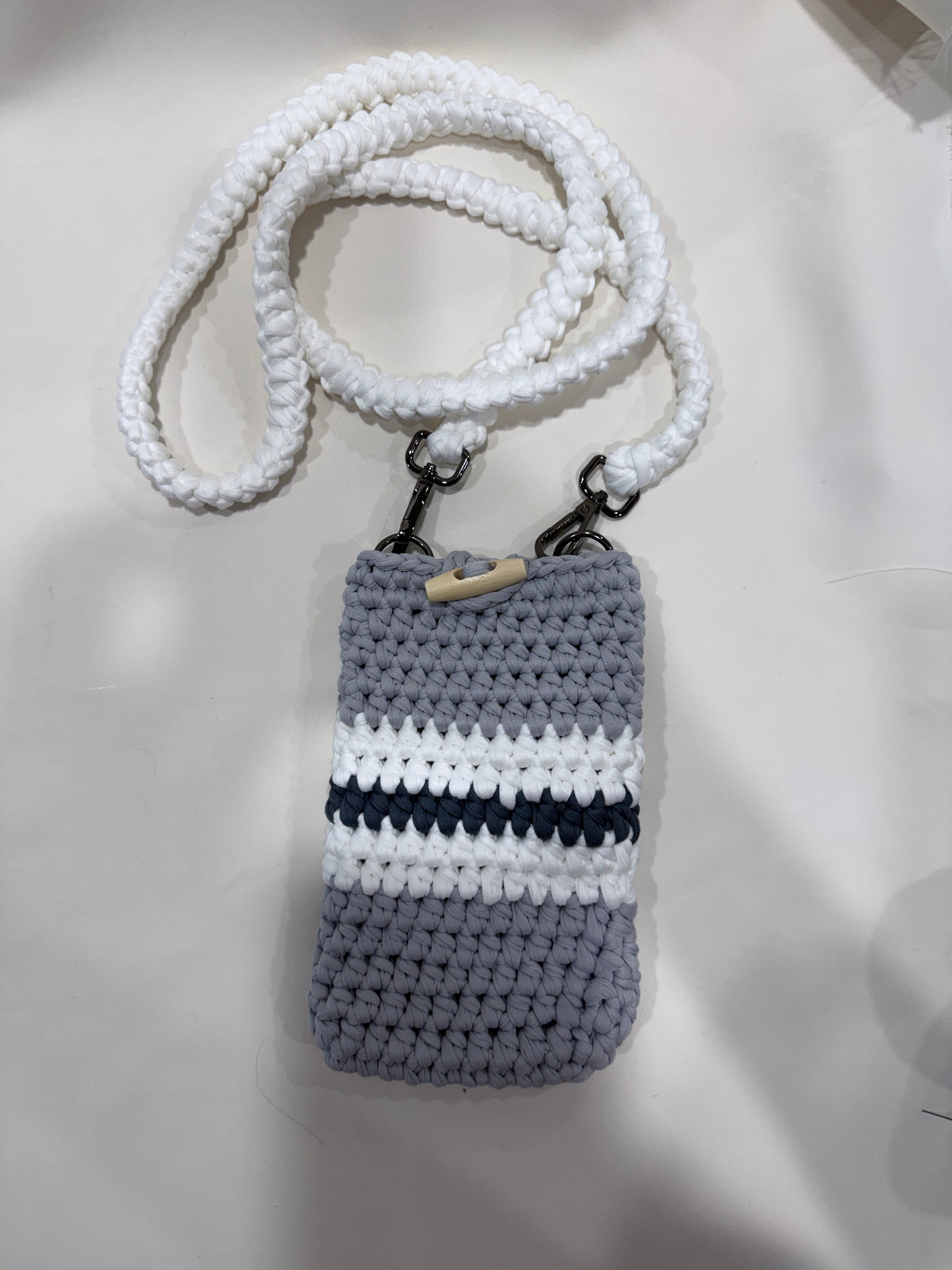 Flat lay handmade crochet chevron phone pouch 7.5 by 4.5 inches natural background