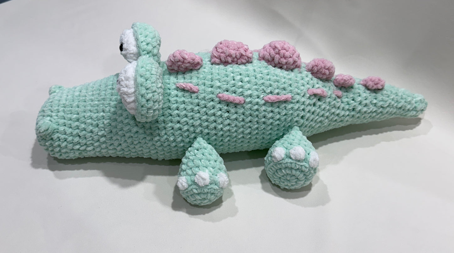 Crocheted crocodile toy on a white background