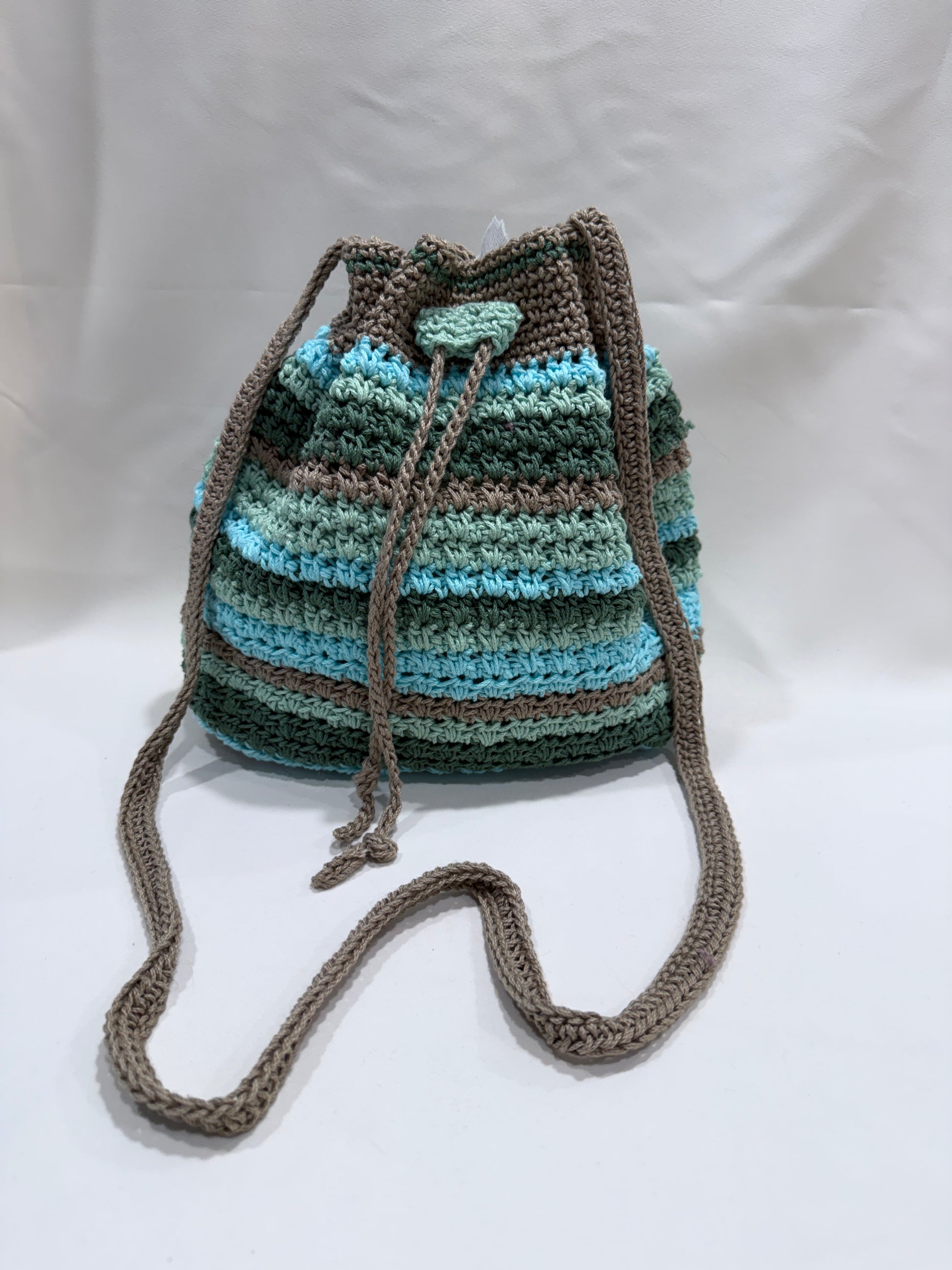 Crocheted bag with a striped pattern on a white background