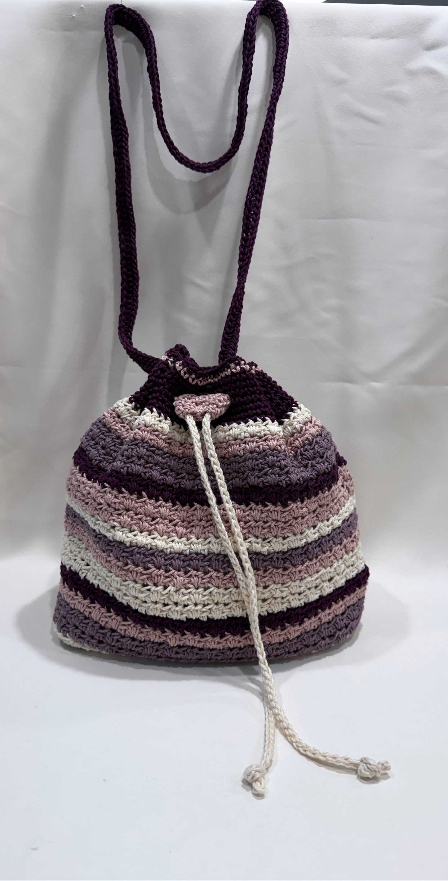 Striped crochet bag with a drawstring on a white surface
