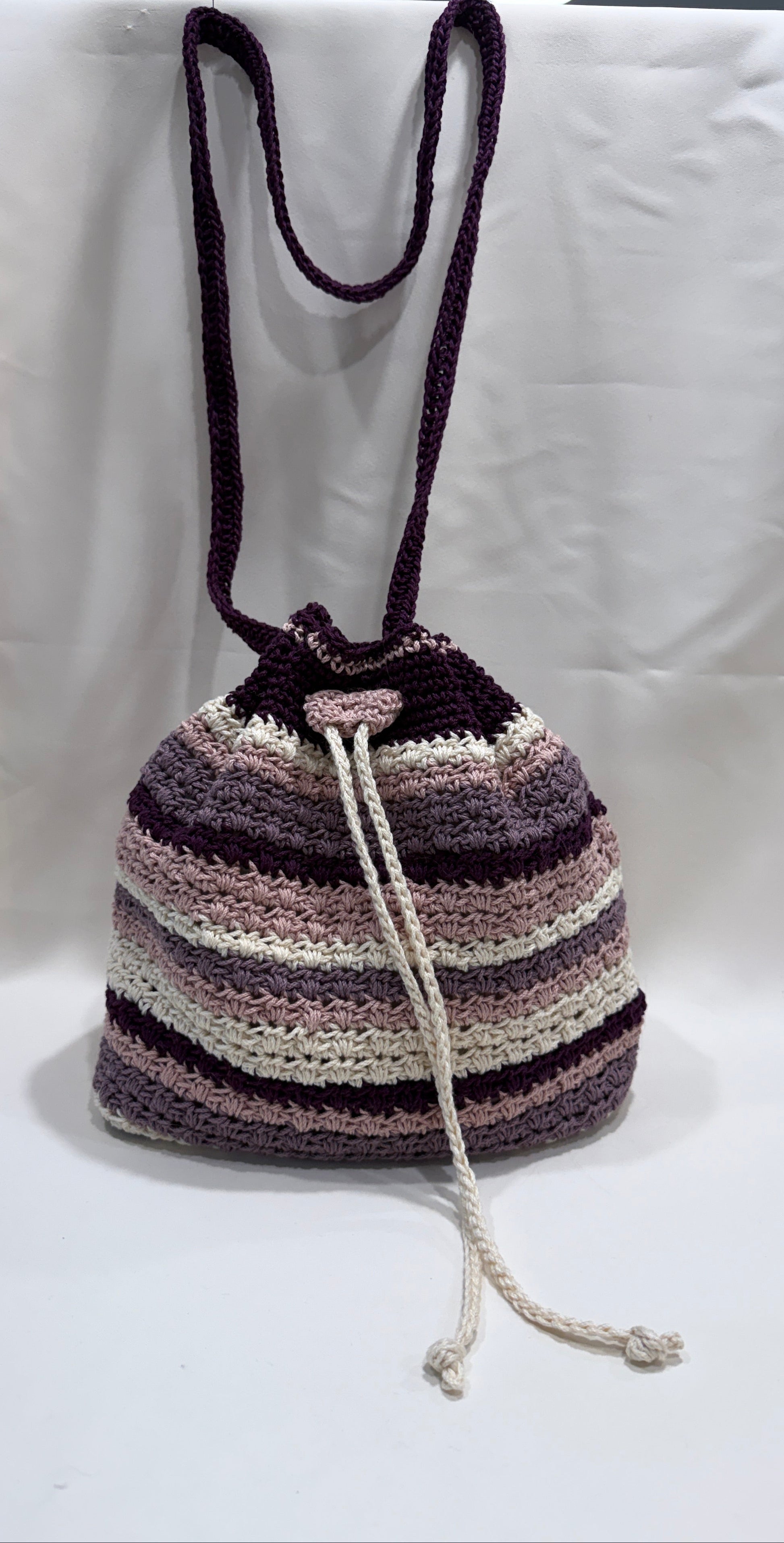 Striped crochet bag with a drawstring on a white surface