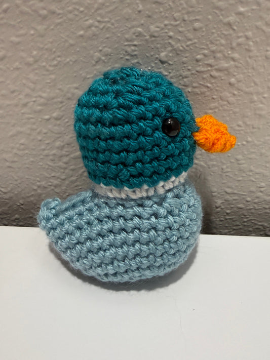 Crocheted mallard duck on a textured wall