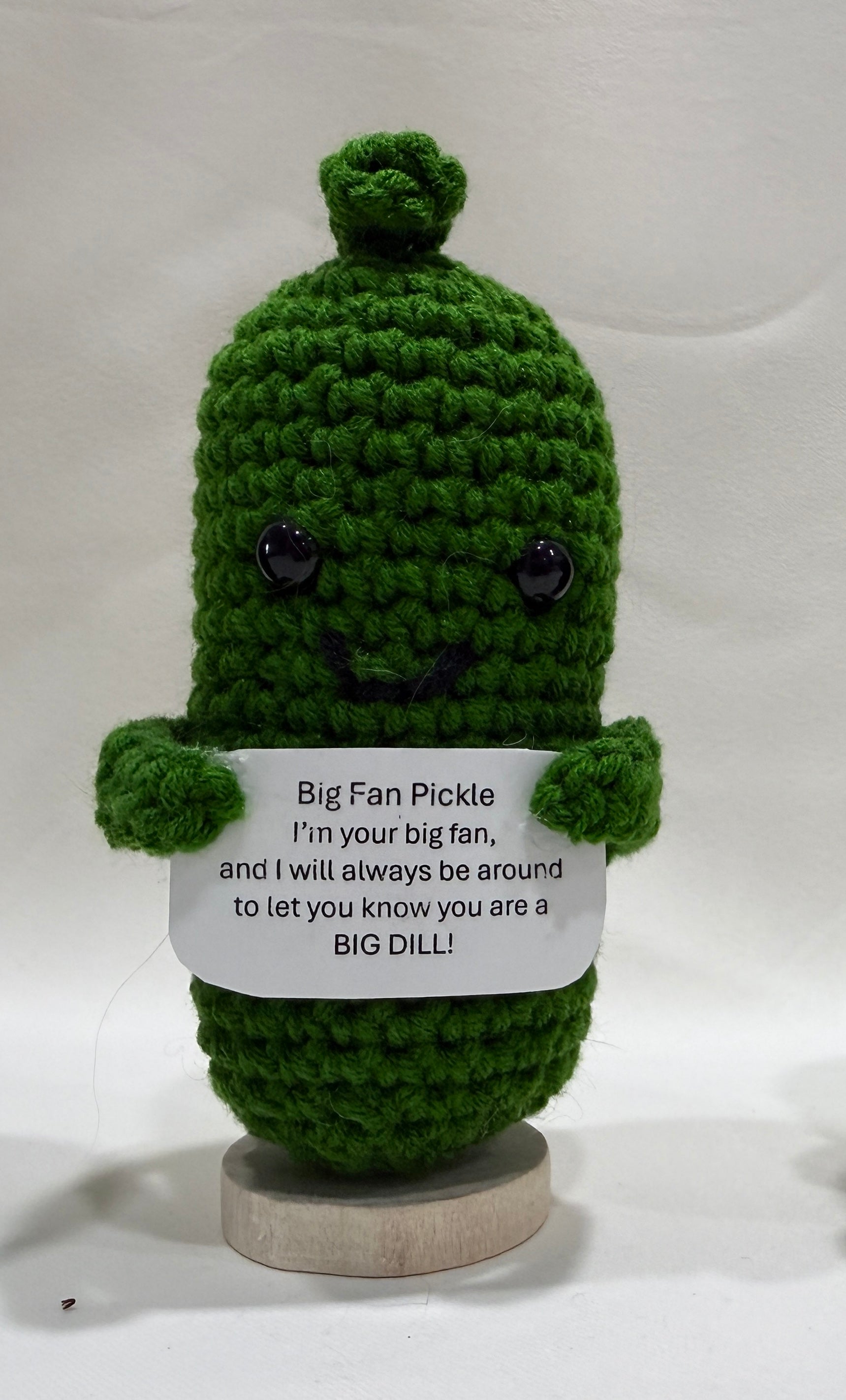 Green crochet pickle with an encouragement sign on a white background