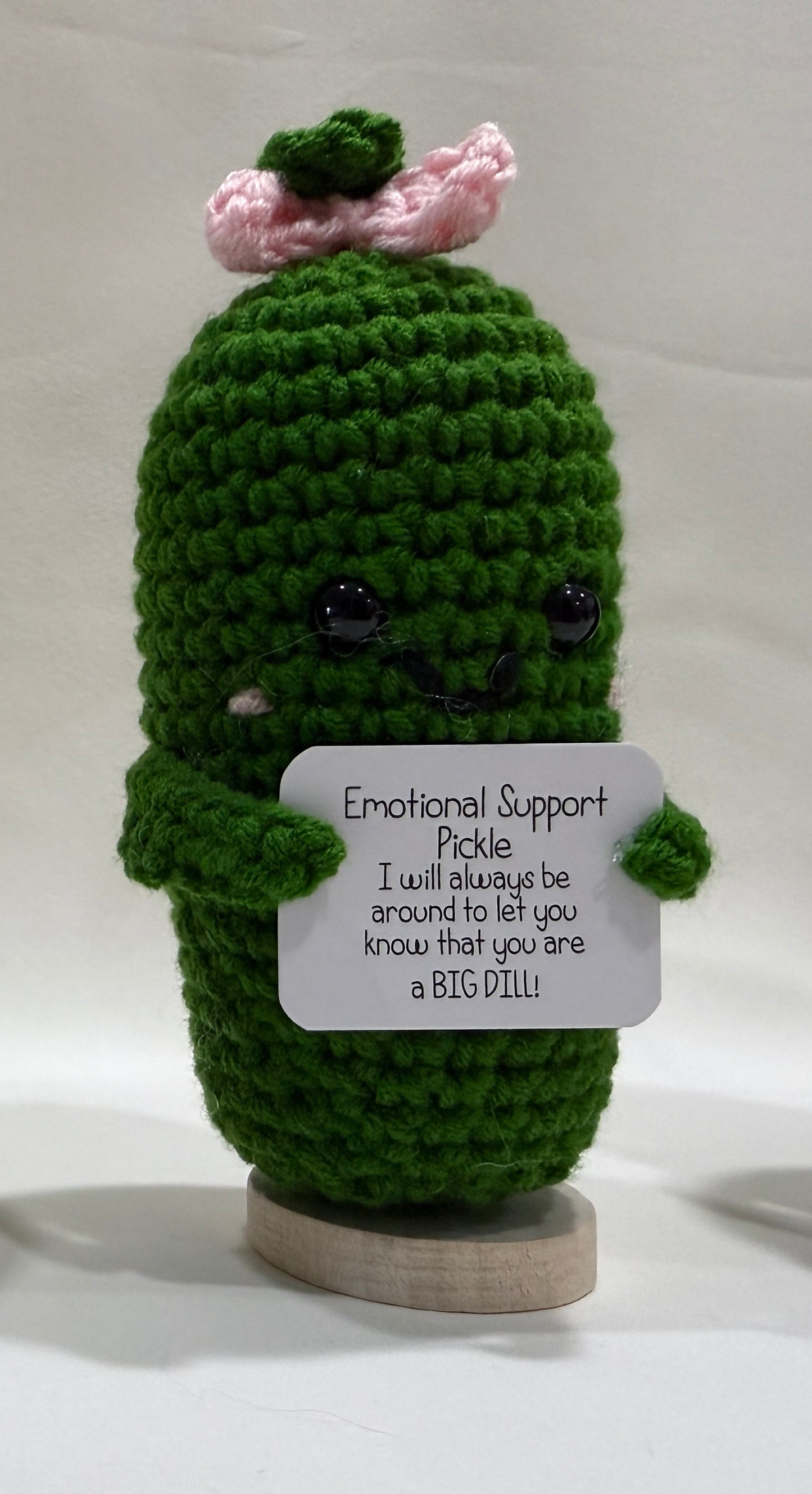 Crocheted pickle with an encouragement sign on a white background