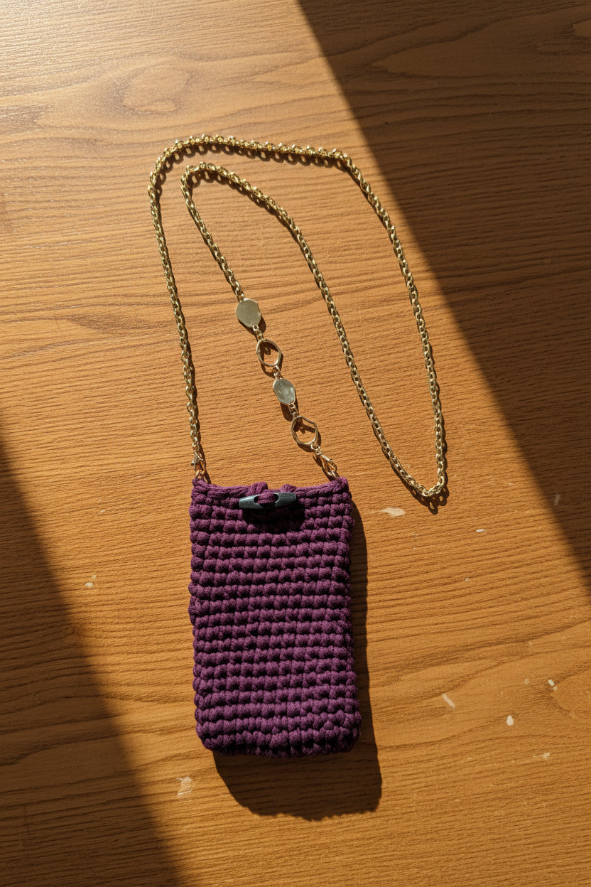 Plum crochet cell phone pouch with a chain strap. 