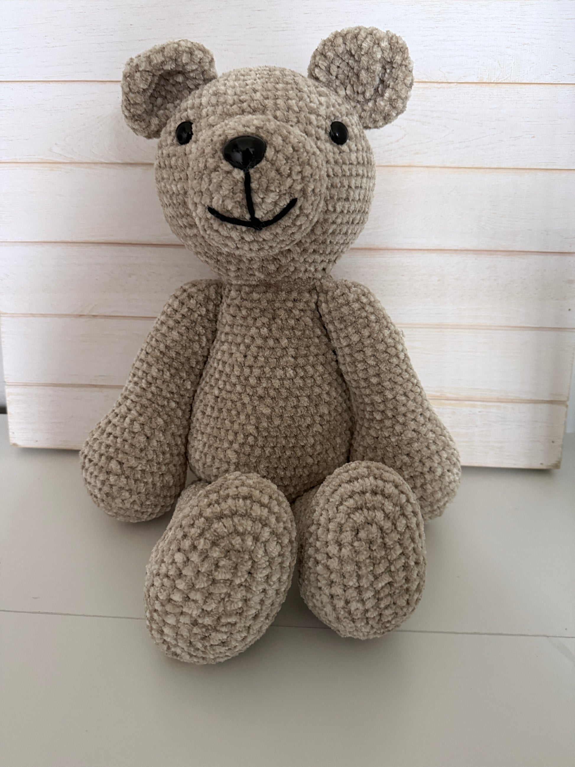 Crochet teddy bear on a wooden surface