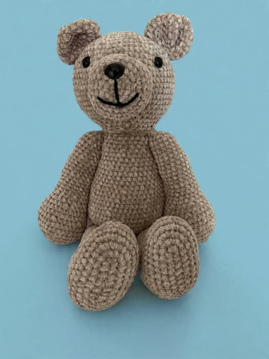 Crocheted teddy bear on a blue background