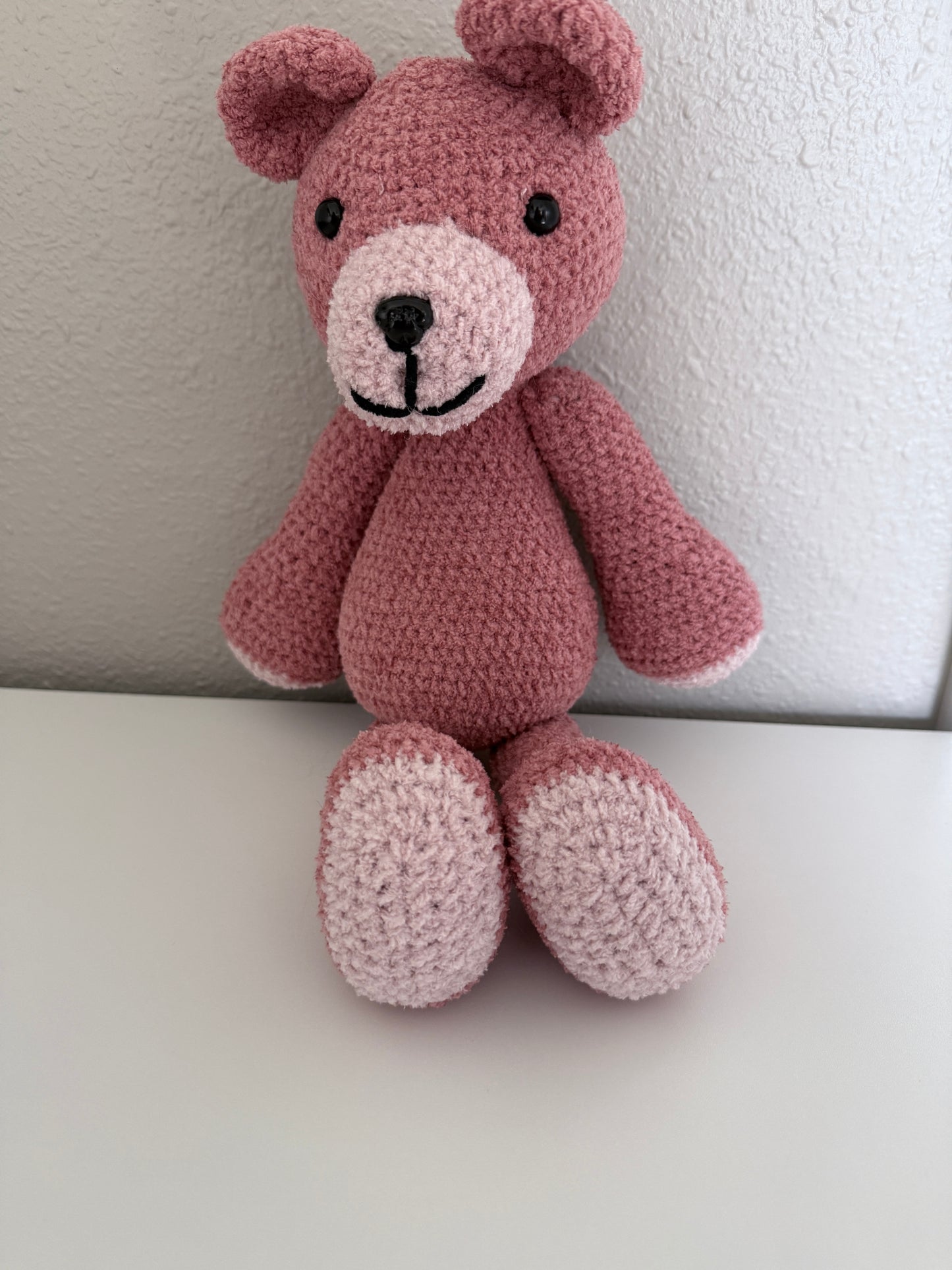 crochet teddy bear against a white wall