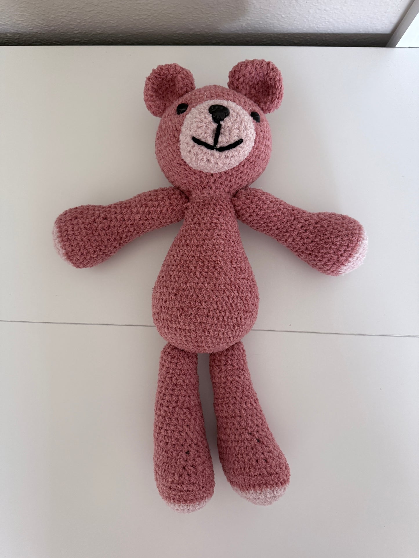Crochet Pink teddy bear toy on a light-colored table