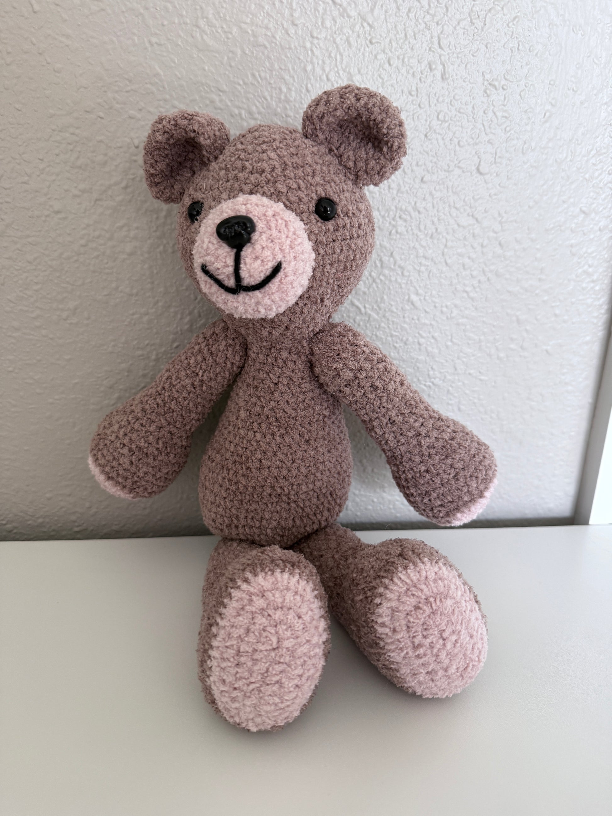 Crochet teddy bear toy on a white background